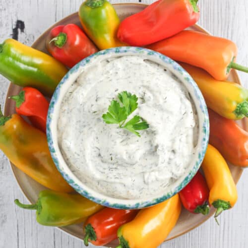top down view of dip in blue crock surrounded by snack peppers
