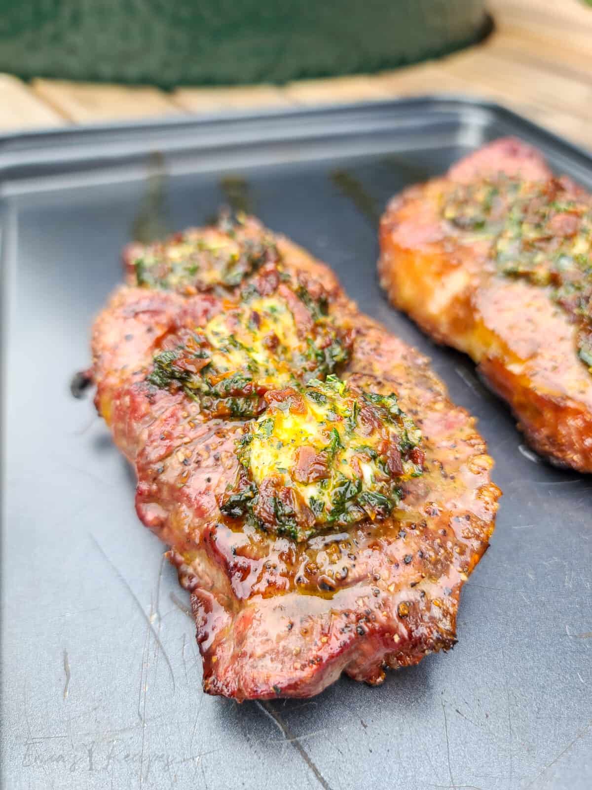 grilled steak on bake sheet topped with sun dried tomato butter