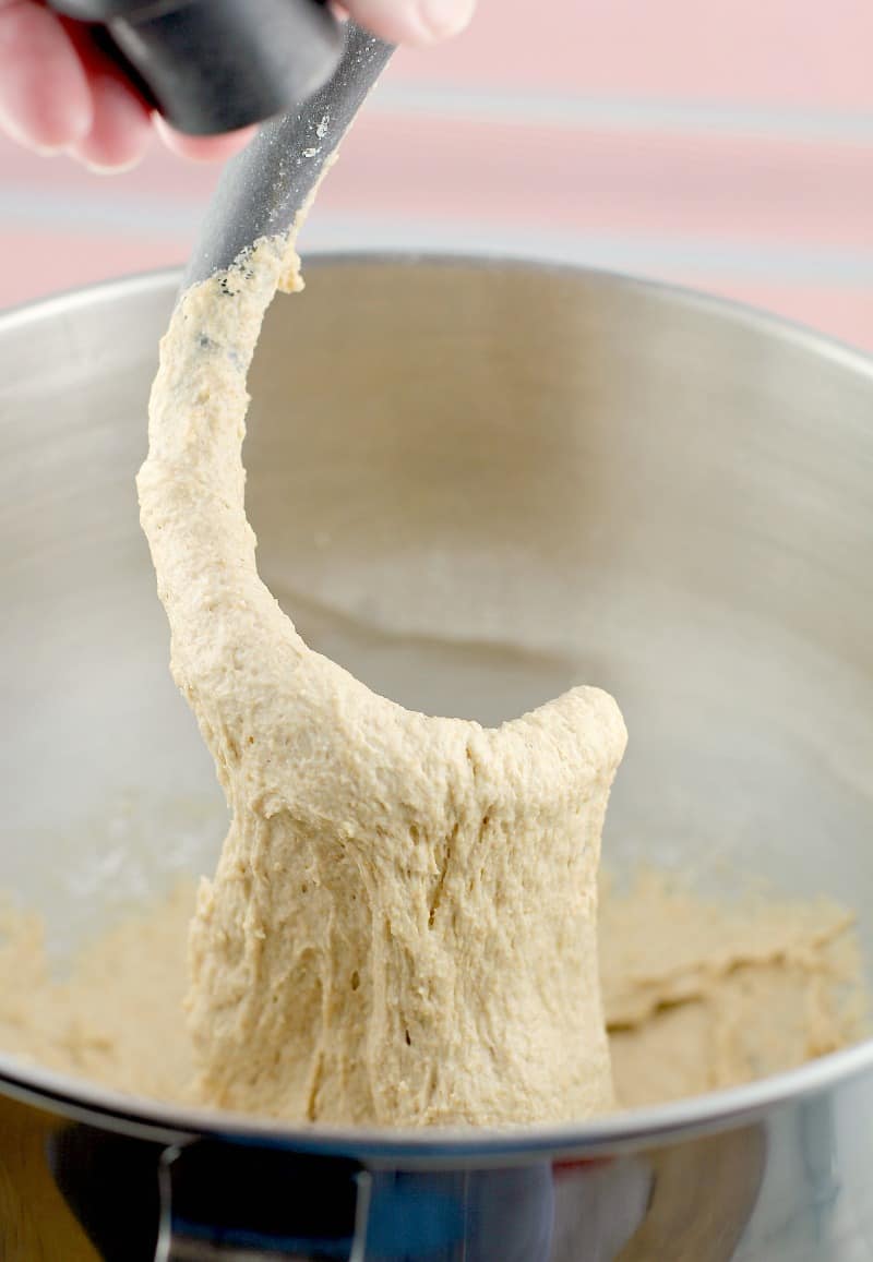 dough hook lifting up dough to show how it is stretchy after the kneading