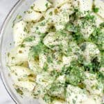 This cozy warm side dish with seasoned boiled potatoes is perfect for St Patrick's Day or any occasion to get your Irish herbed potatoes, Irish food game on. Creamy soft boiled potatoes, tossed in a lemony, buttery, heavily herbed vinaigrette, served at will to a crowd.  #food #recipe #Ireland #Irishpotatoes #boiledpotatoes #potato
