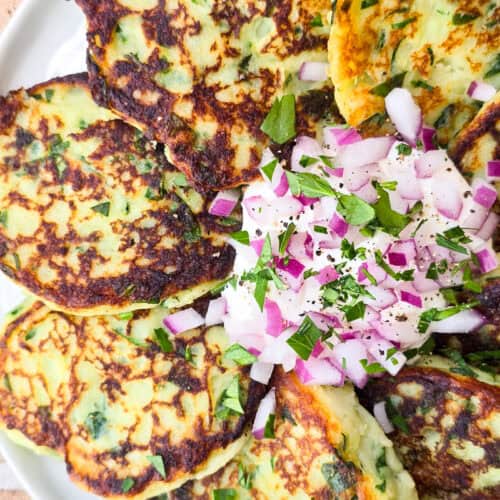 prepared instant mashed potato cakes on plate with sour cream and red onion in the center