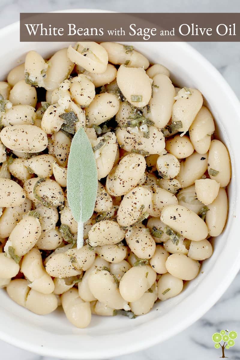 This little recipe for easy white beans is as delightful and flavorful as it is simple and inexpensive to prepare. Creamy white beans simmered in stock with sage and garlic, then tossed in smooth olive oil. Stow this recipe for a quick, vegetarian side dish and simple accompaniment, or spoon over baked potato or rice as a main course. White Beans with Sage and Olive Oil is a perfect little recipe to have on hand. #food #recipe #whitebeans #tuscanbeans #vegetarianrecipe #vegetariansidedish