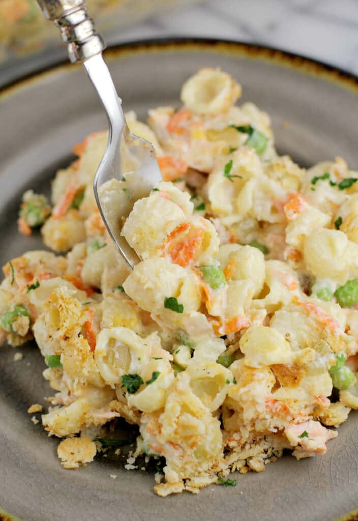 prepared casserole on a serving dish with a fork scooping up a bit in the middle