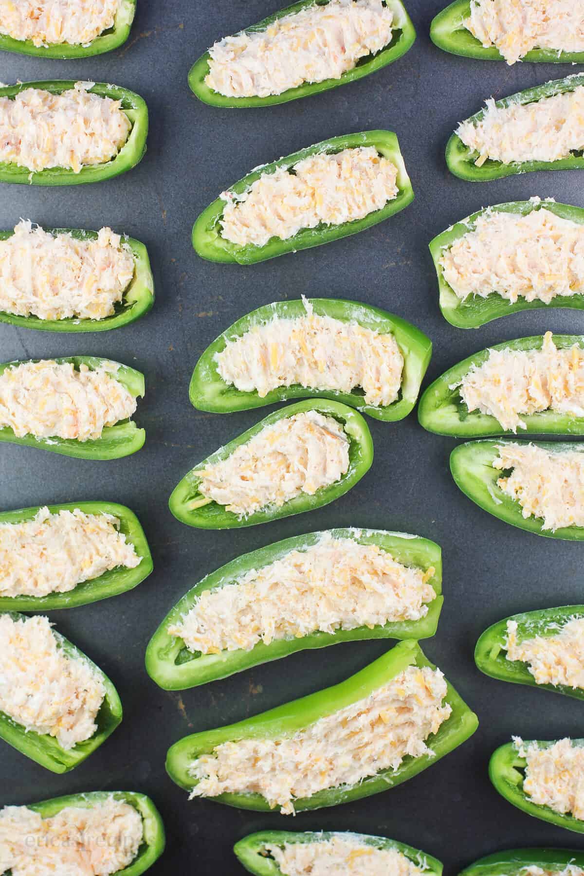 filled jalapenos on bake sheet before cooking