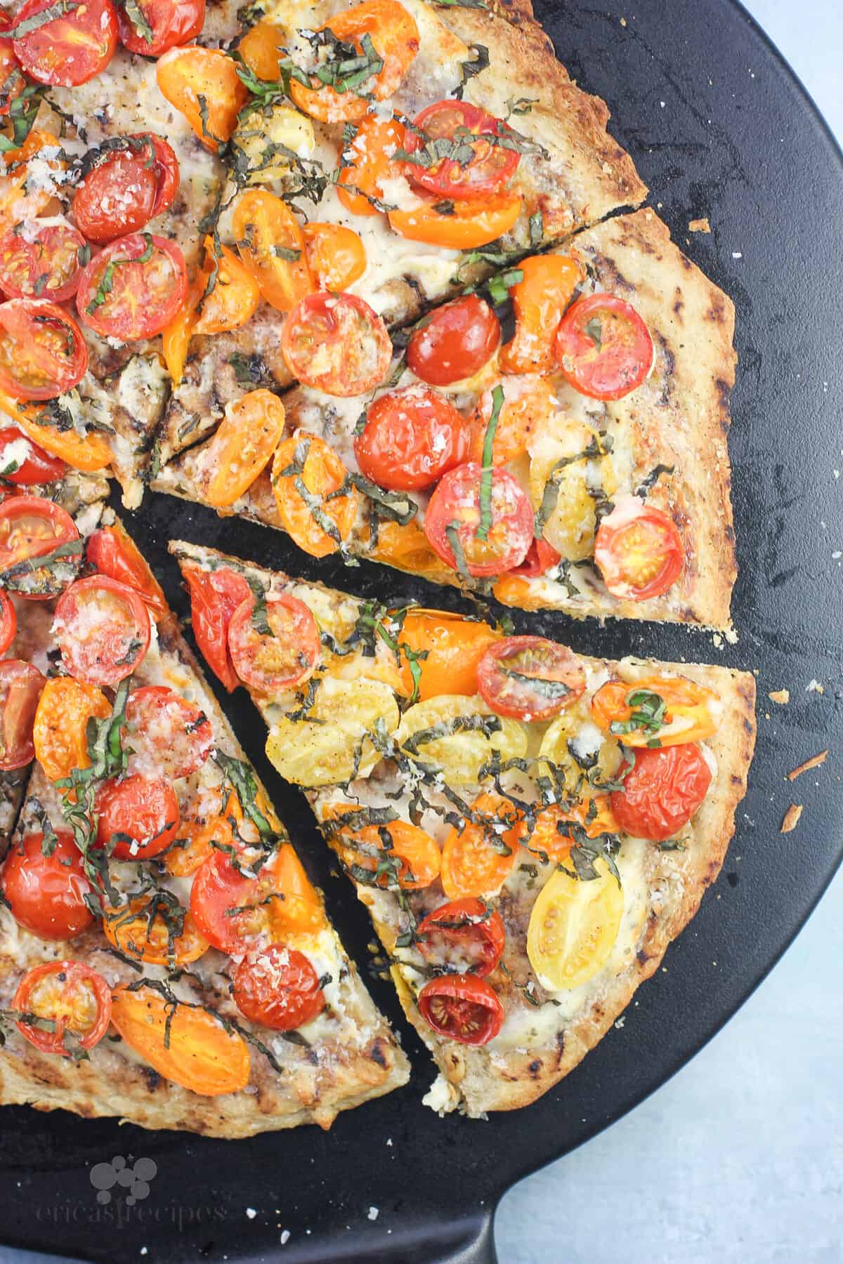 top down view showing prepared pizza sliced on black pizza stone