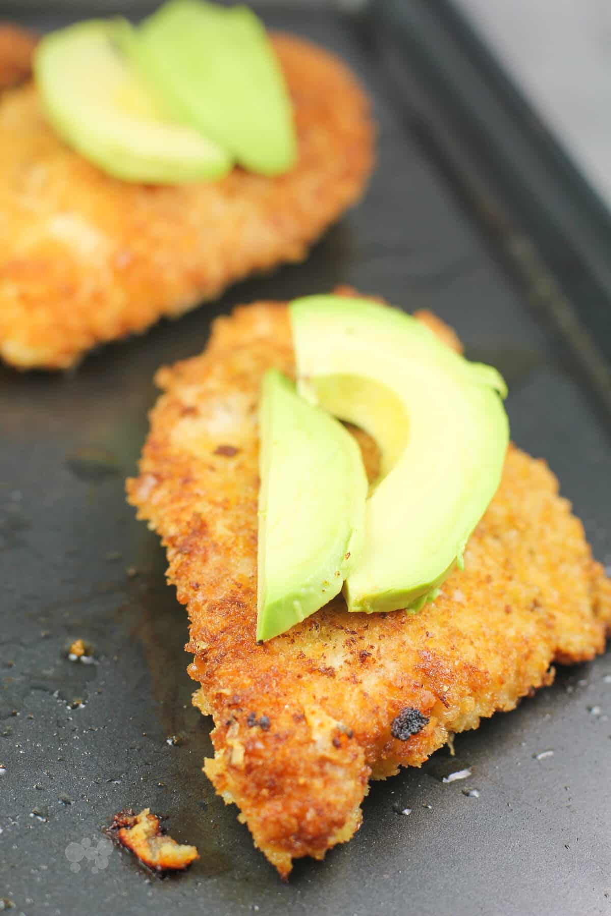 cooked chicken cutlets topped with sliced avocado