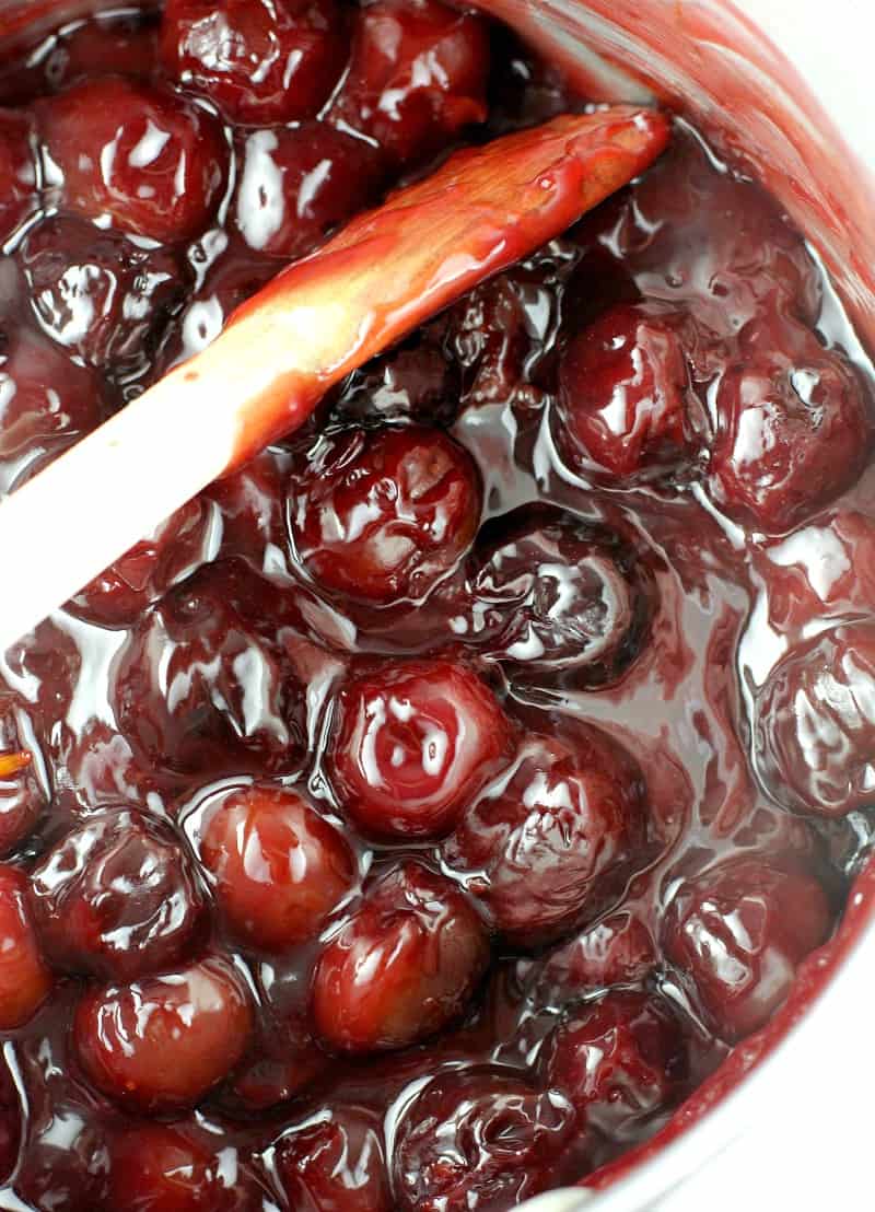 the black cheer pie filling glistening in a saucepan, stirred with a wooden spoon