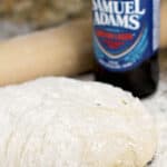 pinterst image with text overlay, dough in front, beer bottle behind