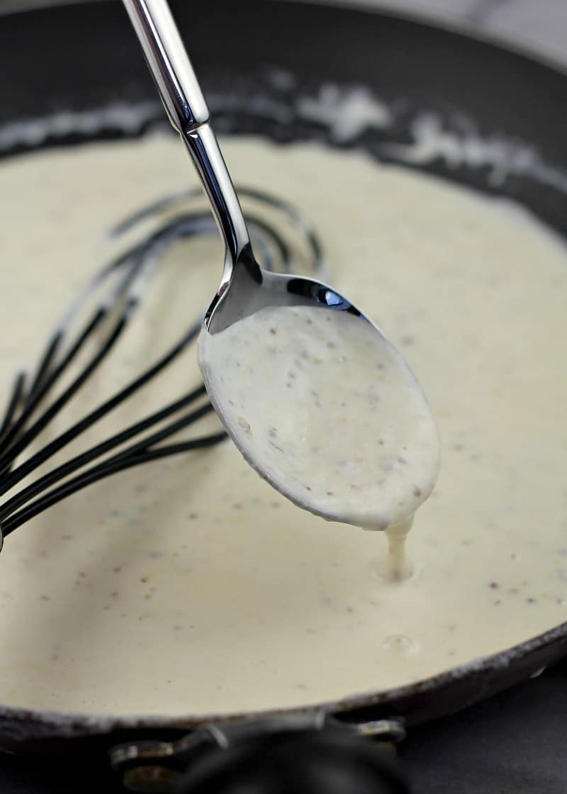 spoon spooning cream sauce in a skillet