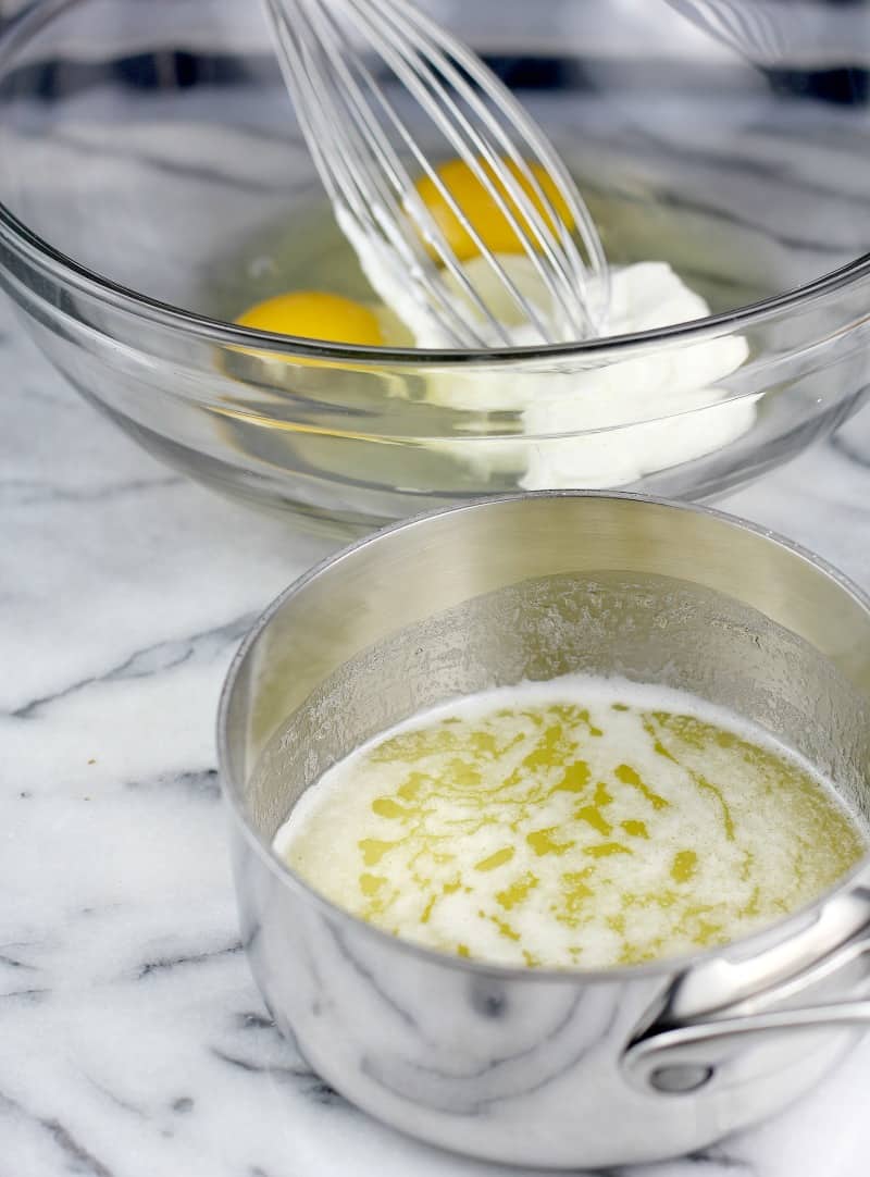 small saucepan with melted butter; eggs and sour cream are in a glass bowl in the background