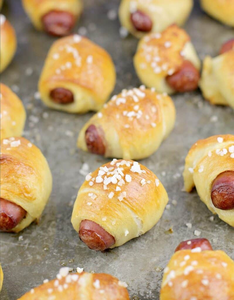 additional view of cooked pretzel bread wrapped smokies on a bake sheet