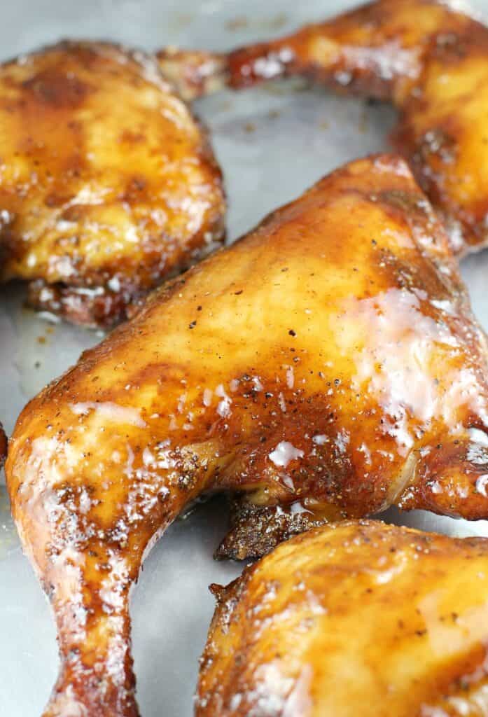glazed smoked chicken quarter on a bake sheet