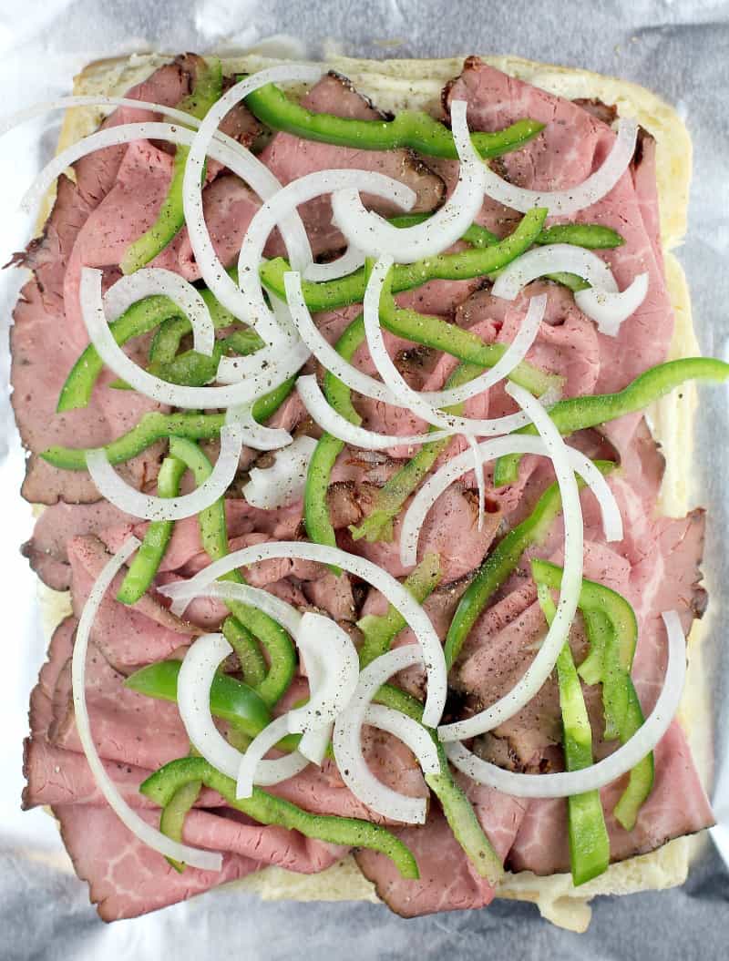 top down view on a half assembled recipe showing the roast beef, onion, and green bell pepper