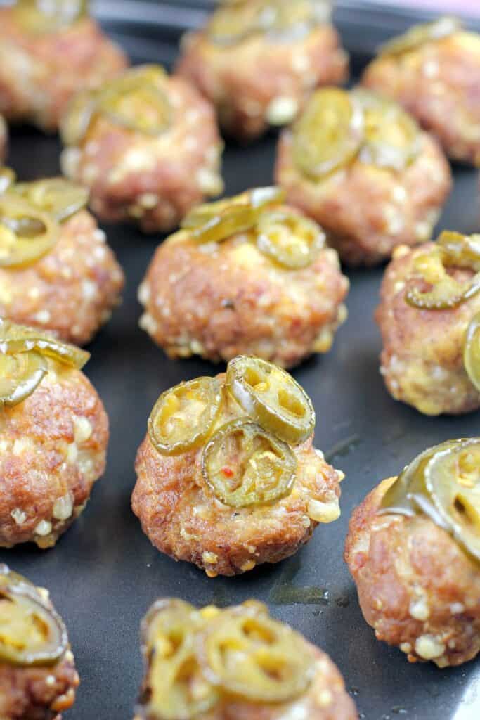 smoked sausage balls topped with jalapenos on metal pan
