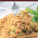 image for pinterest of fork holding spaghetti with text overlay of recipe title Sun-Dried Tomato Pesto Pasta