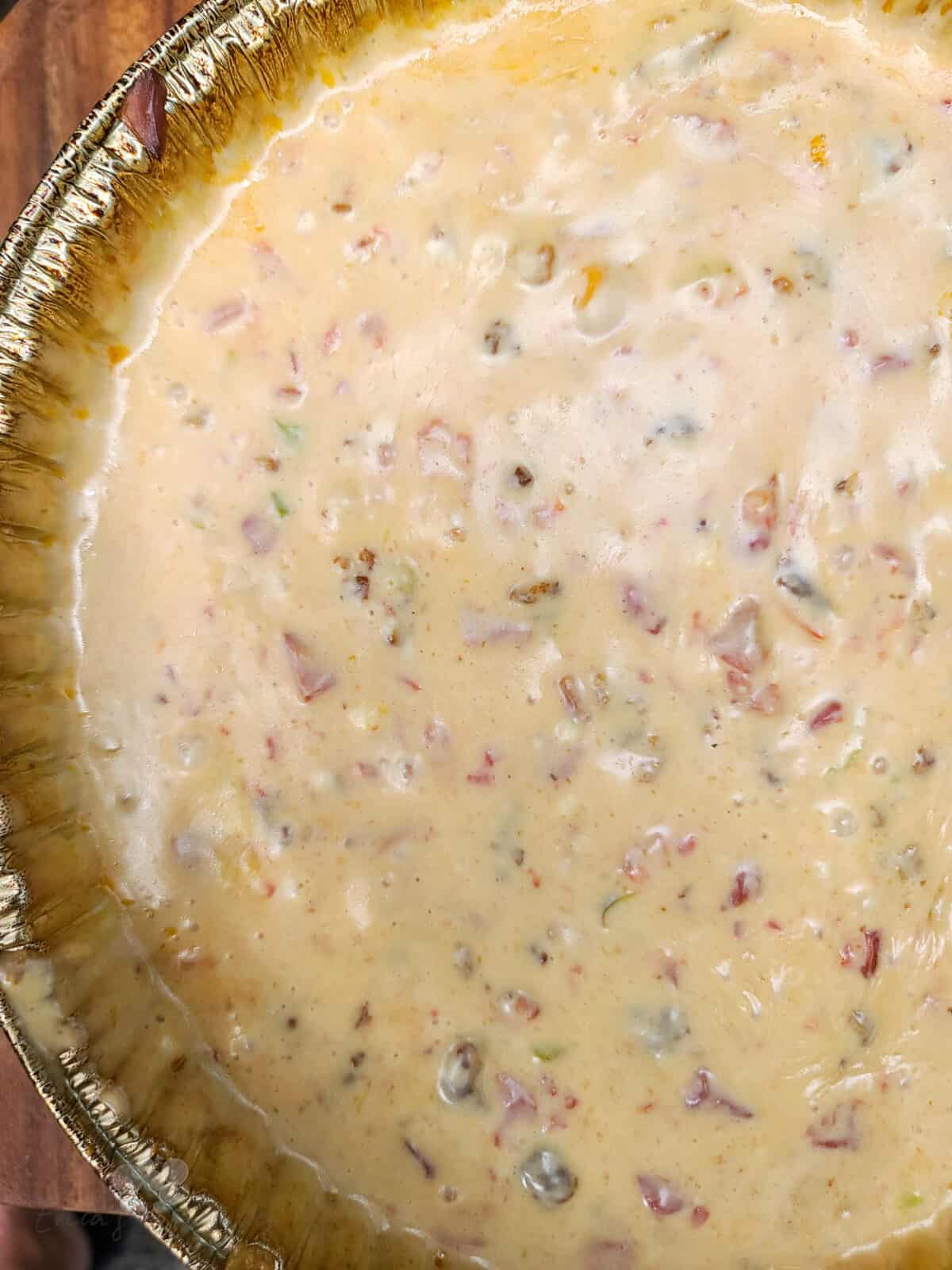 top down view into aluminum tin with prepared queso