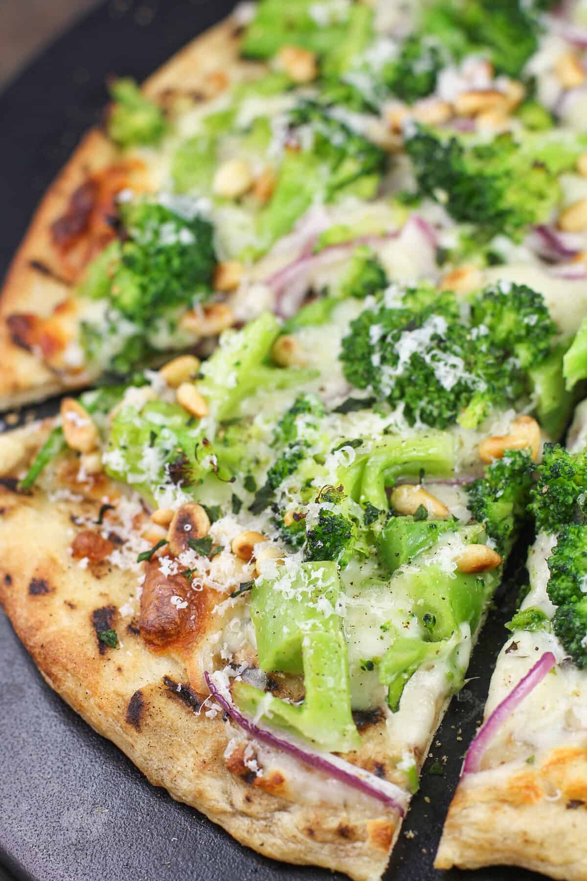 prepared broccoli pizza on black stone