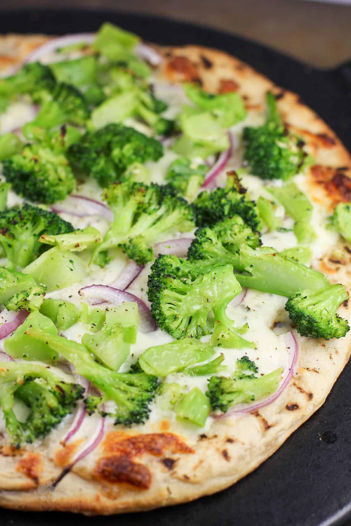 cooked pizza on black stone, right out of the oven before adding last ingredients