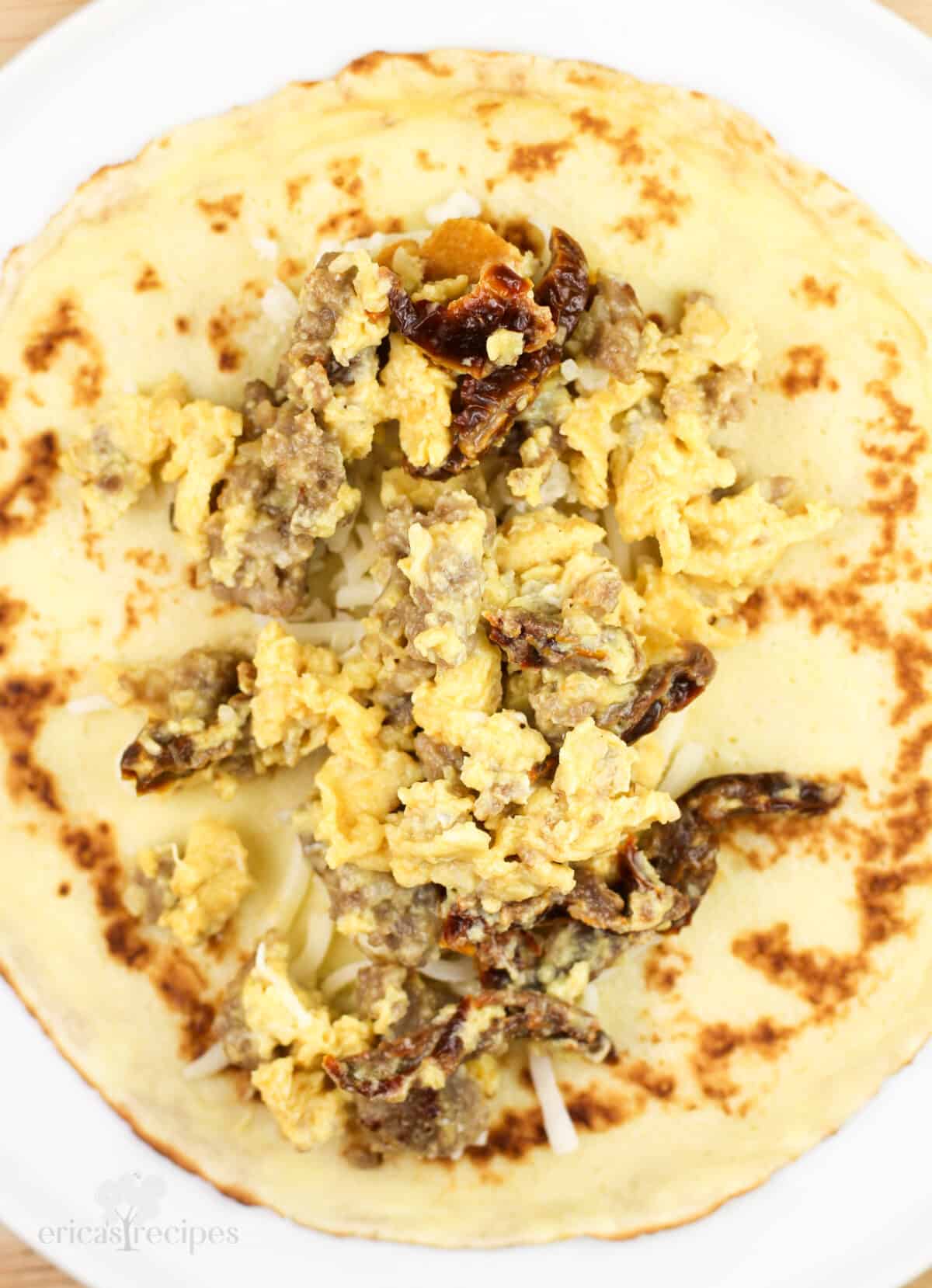 egg and sausage crepe filling on open crepe