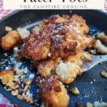 cooked garlic parmesan tater tots on black surface with spoon; text overlay recipe title for pinterest