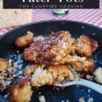 cooked garlic parmesan tater tots on black surface with spoon; text overlay recipe title for pinterest