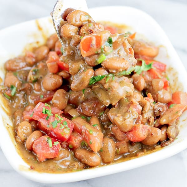 beans in small white dish topped with diced tomato and green onion