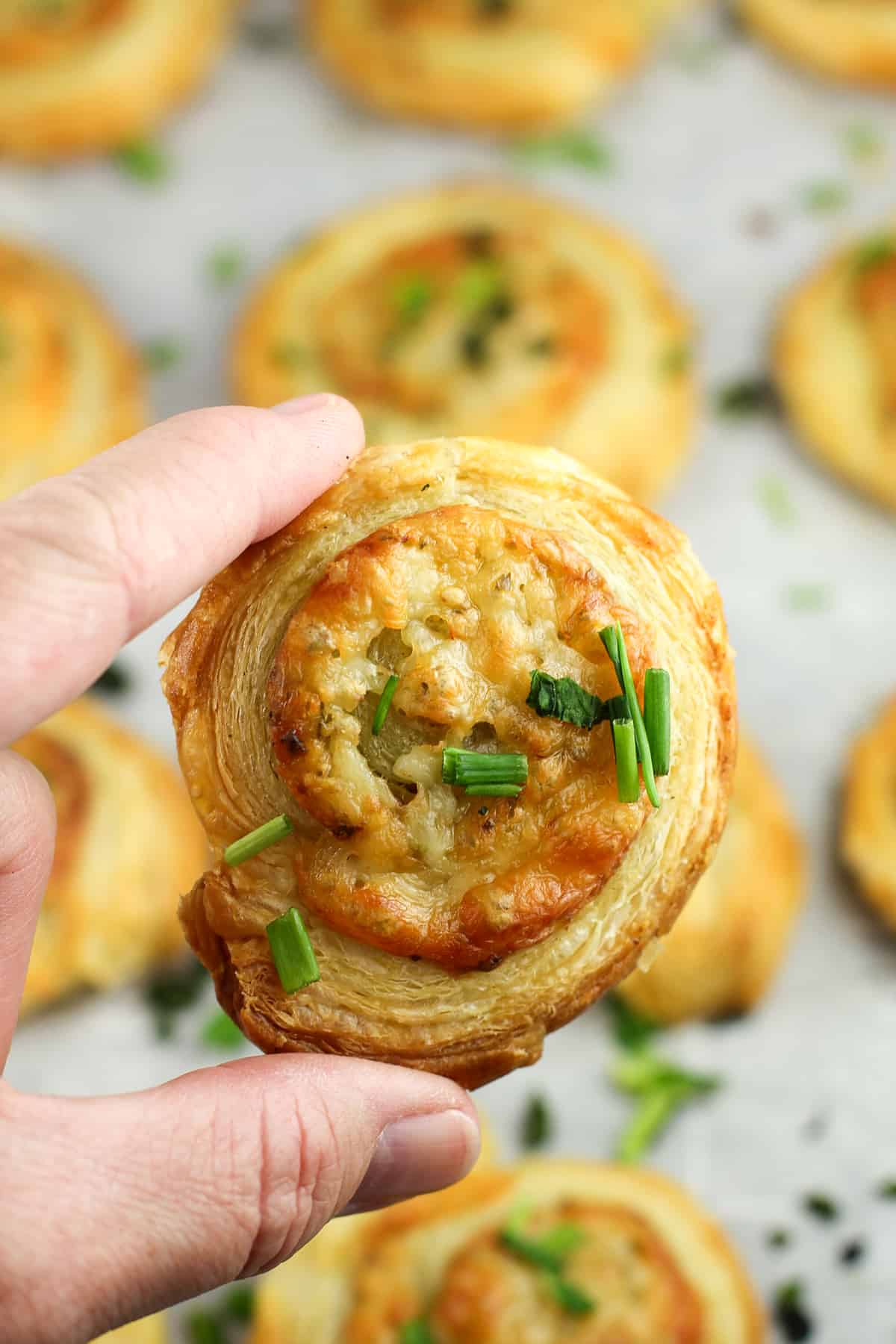 hand holding a cooked pastry pinwheel