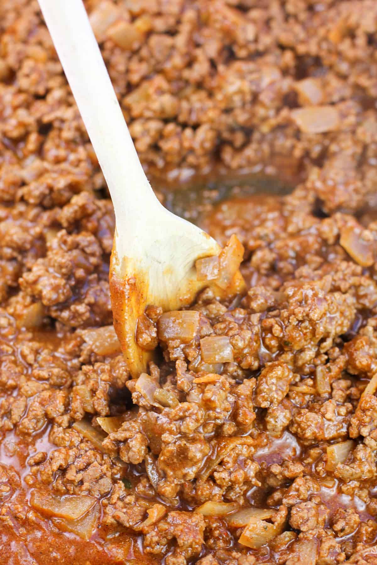 prepared taco meat in skillet with wooden spoon