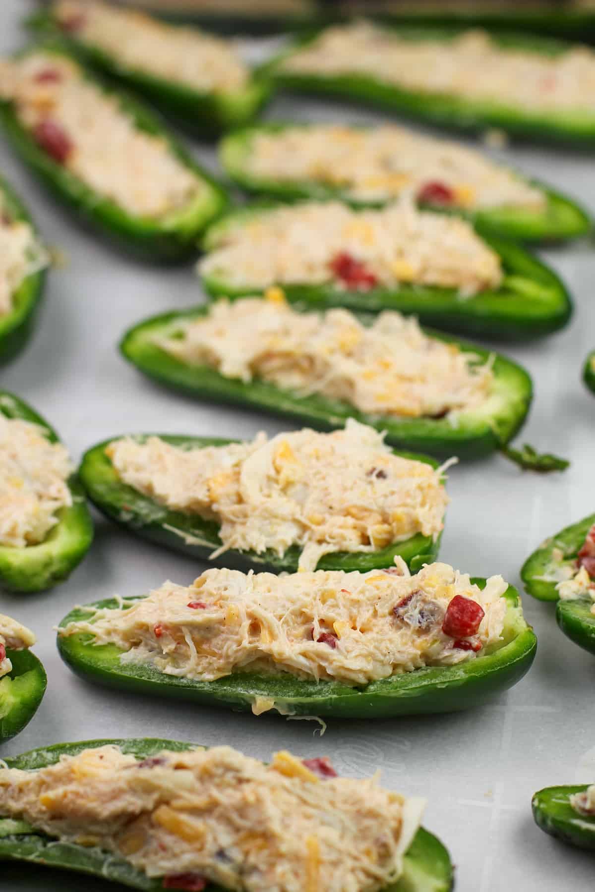 stuffed jalapeno halves on bake sheet prior to cookin
