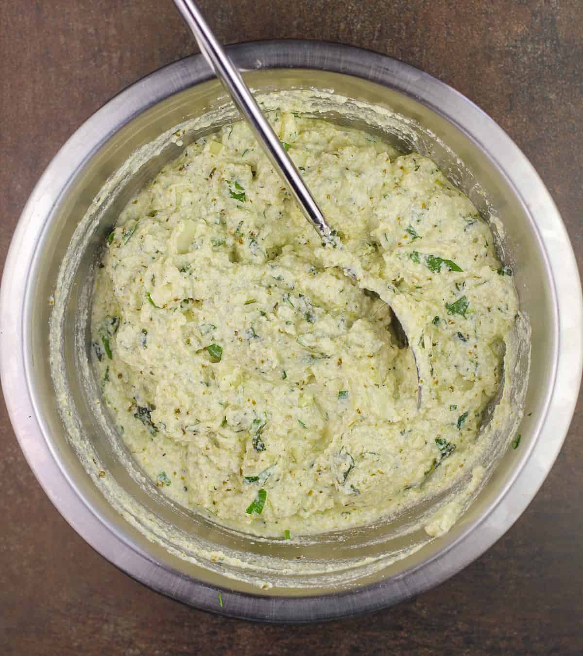 prepared pesto ricotta in metal bowl with spoon