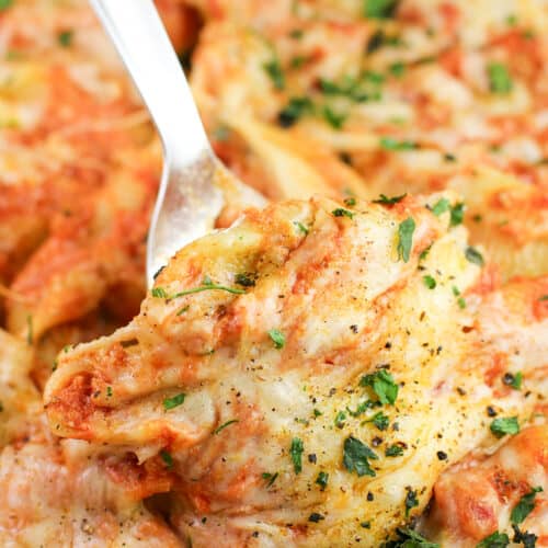 spatula lifting a Cajun Shrimp and crab stuffed shell in casserole dish