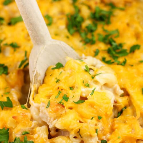 wood spoon inserted into cooked chicken casserole