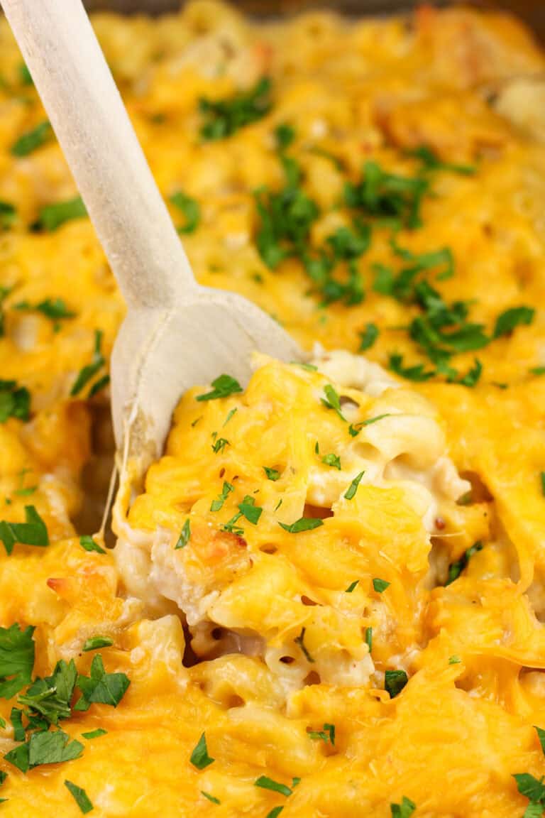 wood spoon inserted into cooked chicken casserole